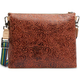 Brown leather clutch with floral patterns and a colorful strap on a white background