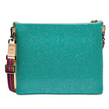 A turquoise glittery crossbody bag with a colorful woven strap and beige leather accents, shown against a plain white background.