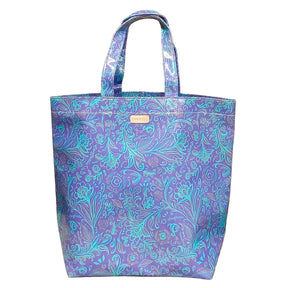 Blue floral patterned tote bag on a beige cushion with wicker background