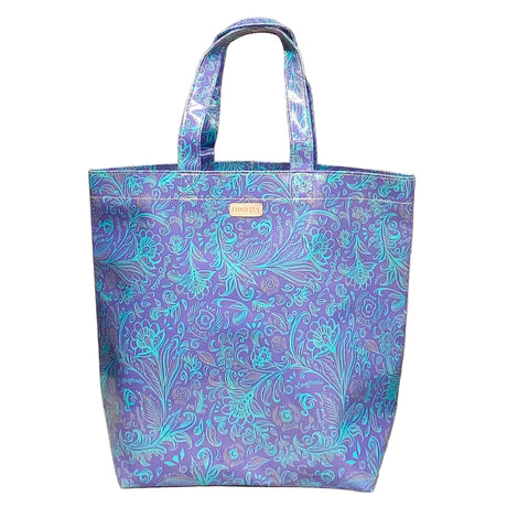 Blue floral patterned tote bag on a beige cushion with wicker background