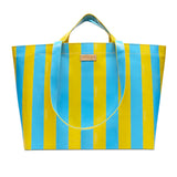 Striped blue and yellow tote bag with a visible brand label on a white background