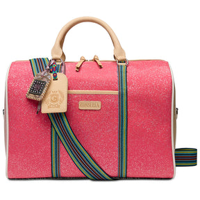A structured pink jet setter bag with beige leather handles and trim, featuring a colorful woven strap and a silver metal clasp, shown against a plain white background.