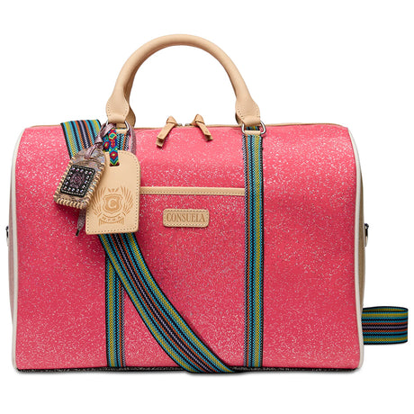 A structured pink jet setter bag with beige leather handles and trim, featuring a colorful woven strap and a silver metal clasp, shown against a plain white background.