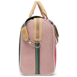 A structured pink jet setter bag with beige leather handles and trim, featuring a colorful woven strap and a silver metal clasp, shown against a plain white background.
