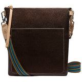Brown leather crossbody bag with a colorful strap on a white background