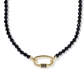 Black beaded necklace with a gold clasp on a white background