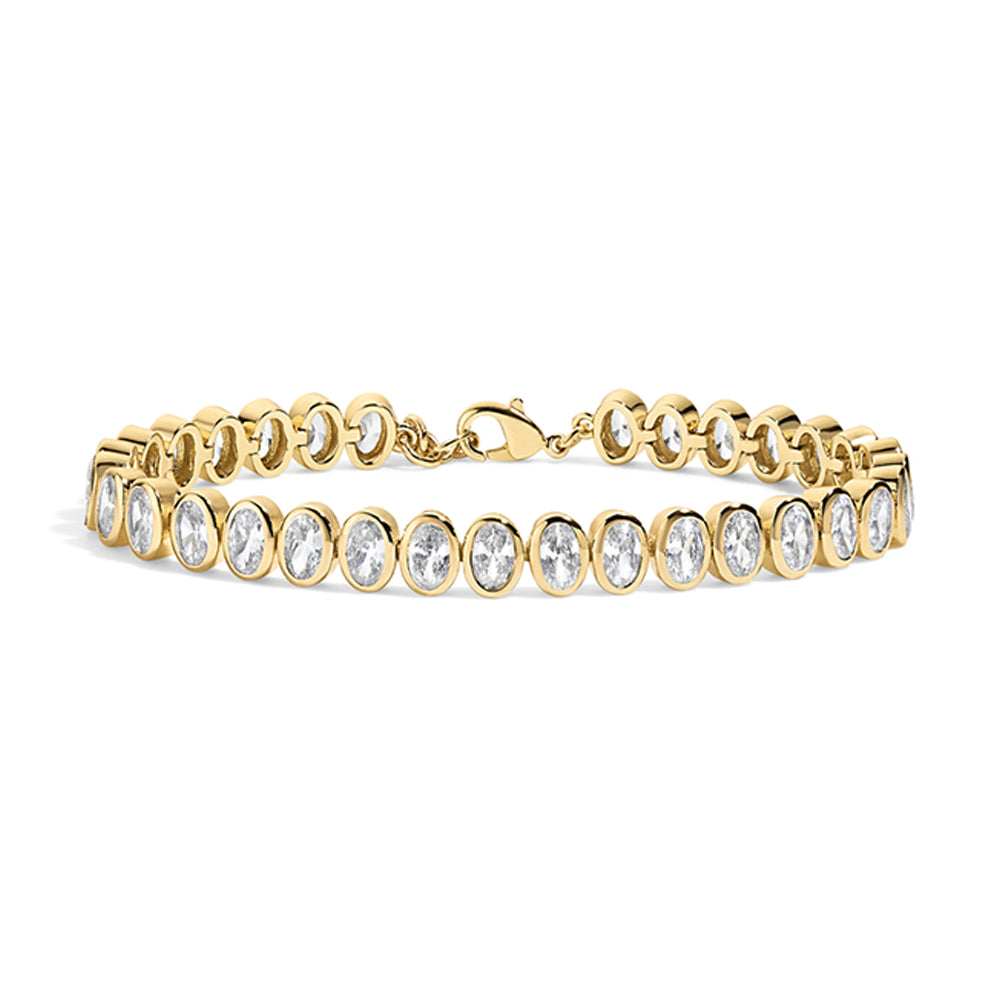 A yellow gold tennis bracelet featuring a row of bezel-set oval clear gemstones, displayed on a clean white background.