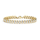 A yellow gold tennis bracelet featuring a row of bezel-set oval clear gemstones, displayed on a clean white background.