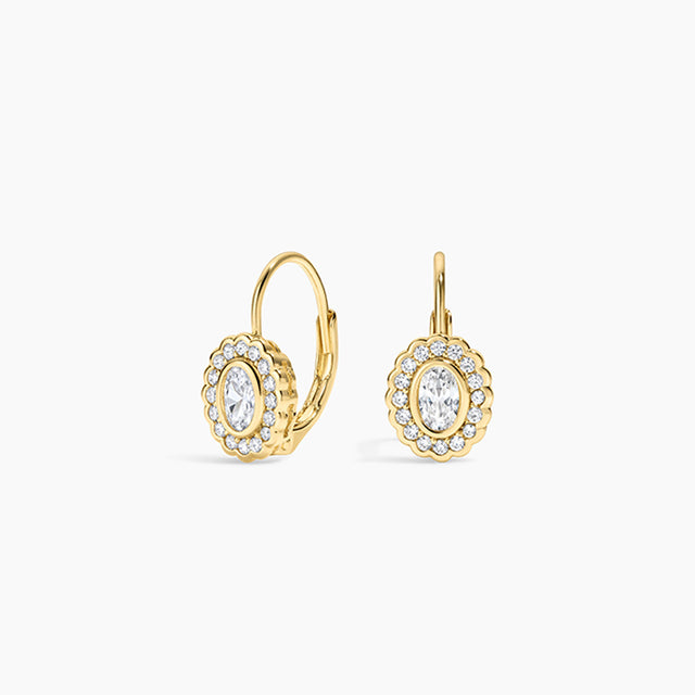 A pair of gold leverback earrings with oval halo settings, featuring clear marquise-cut center stones surrounded by small round stones, shown on a light gray background.
