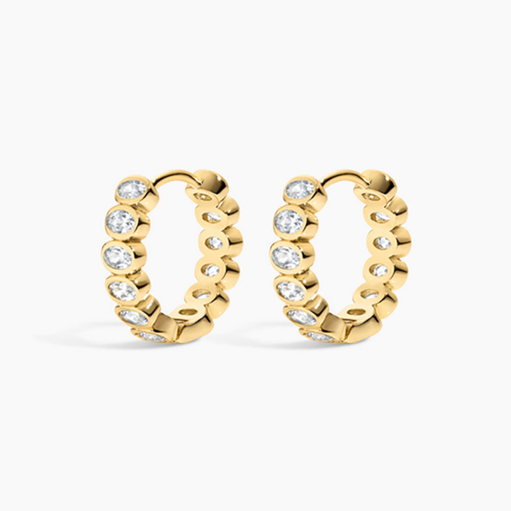 Gold hoop earrings with embedded diamonds on a white background