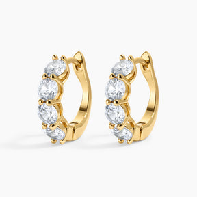 Gold hoop earrings with clear gemstones on a white background