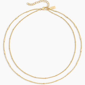 Two gold necklaces on a white background
