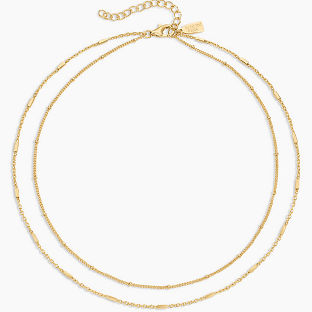 Two gold necklaces on a white background