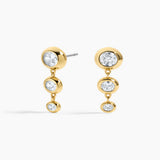 Gold earrings with clear gemstones on a white background