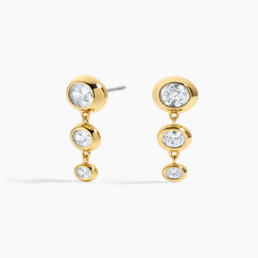 Gold earrings with clear gemstones on a white background