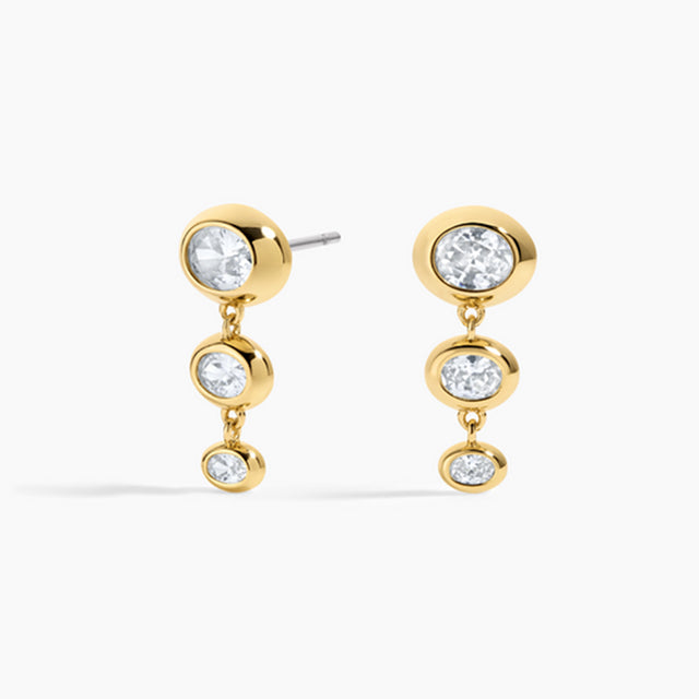 Gold earrings with clear gemstones on a white background