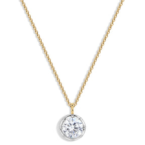 A delicate gold chain necklace with a round bezel-set clear gemstone pendant on a white background.