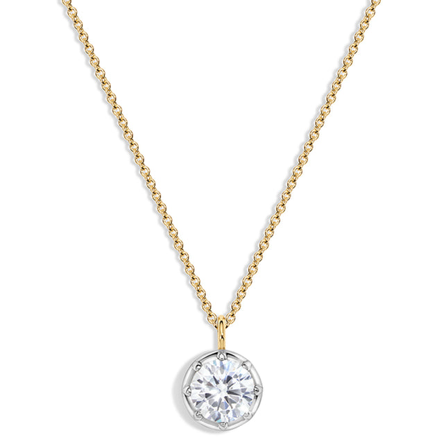 A delicate gold chain necklace with a round bezel-set clear gemstone pendant on a white background.