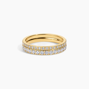 A yellow gold eternity ring featuring two rows of pavé-set round diamonds on a clean white background.