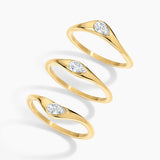 Three gold rings with marquise-cut clear gemstones, arranged diagonally on a clean white background.