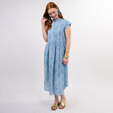 Woman wearing a blue patterned dress on a white background