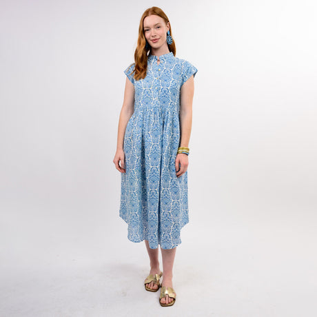 Woman wearing a blue patterned dress on a white background