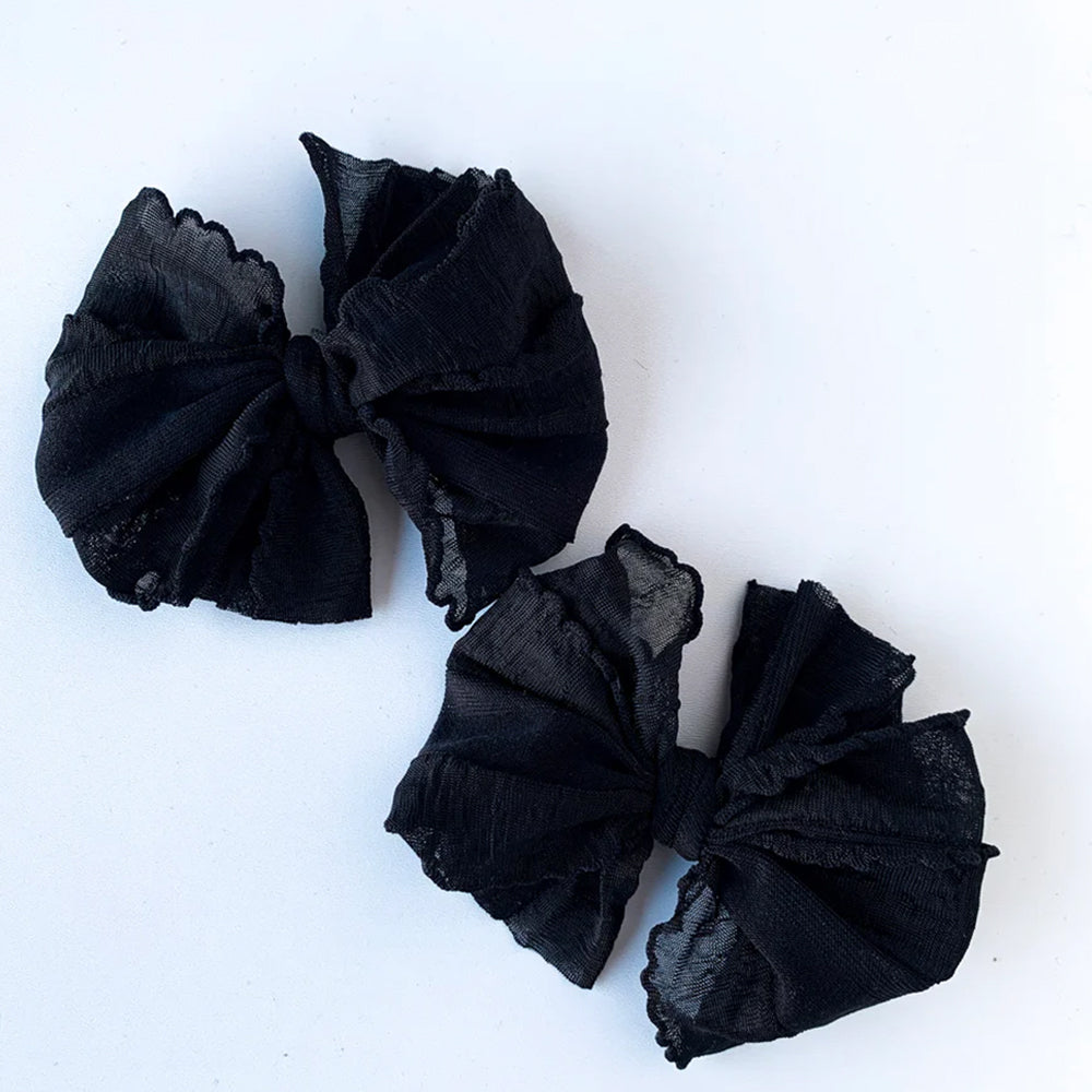 Two black scrunchies on a white background