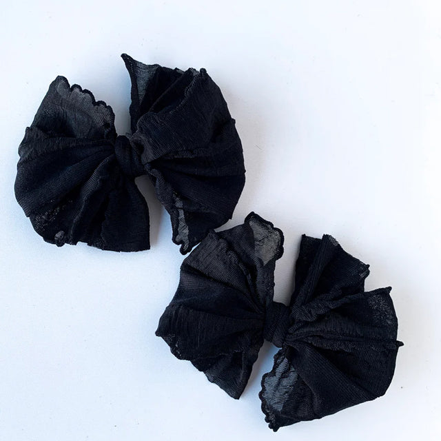 Two black scrunchies on a white background