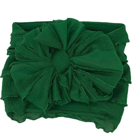 Green headband with a large bow on a white background