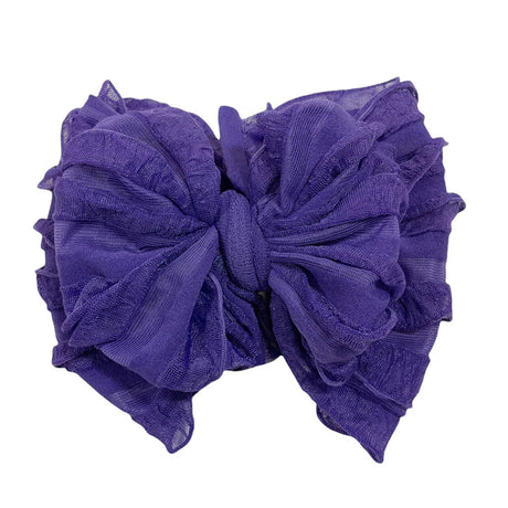Purple bow hair accessory on a white background