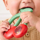Baby holding a red and green teething toy