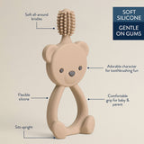 Bear-shaped toothbrush with text highlighting features on a beige background