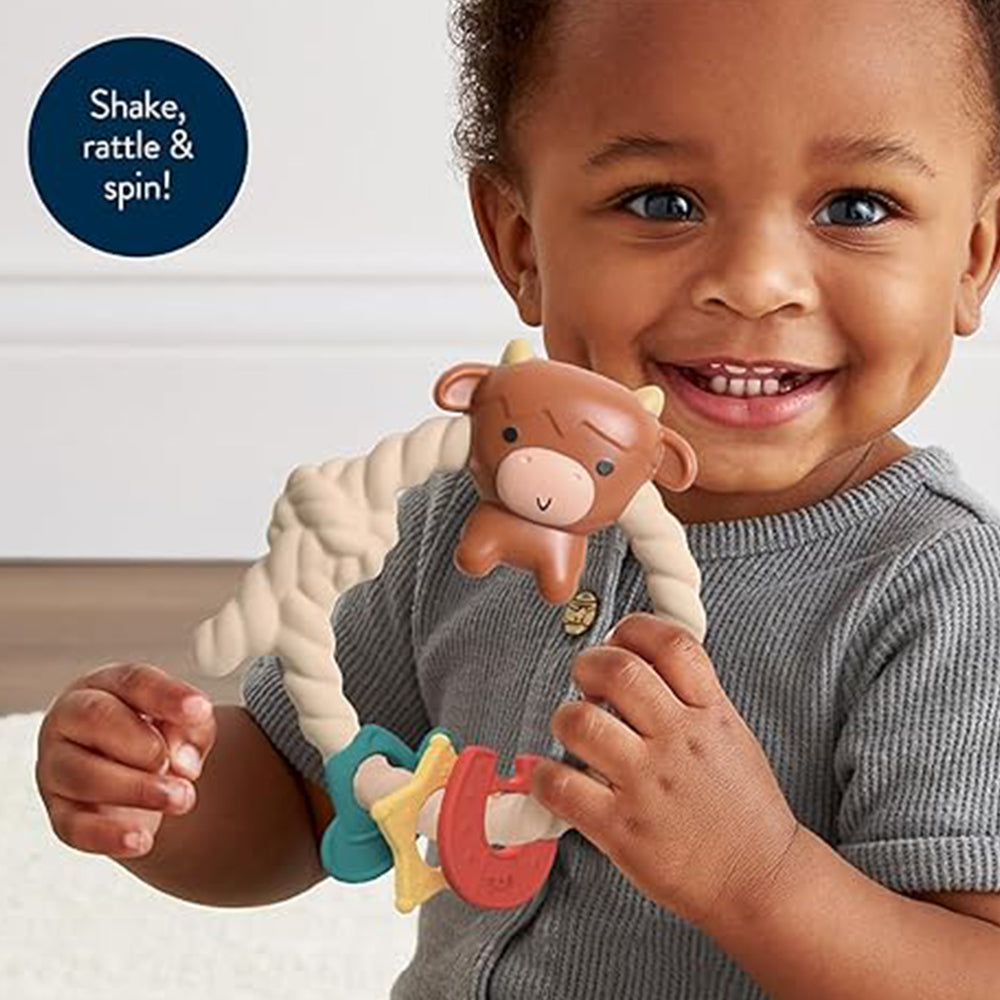 Child holding a toy with text 'Shake, rattle & spin!' on a white background
