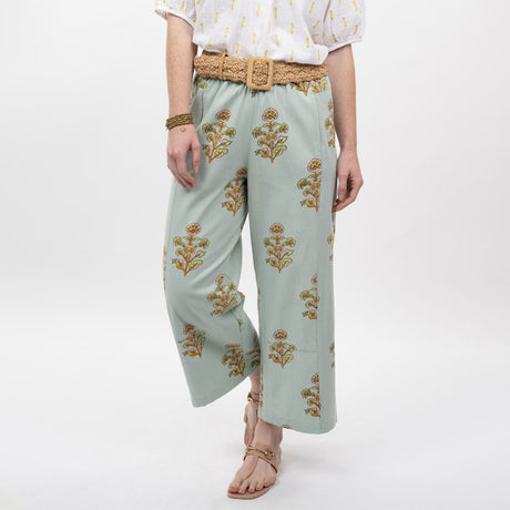 Light blue pants with floral patterns worn by a person on a white background