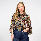 Woman wearing a floral blouse and jeans on a white background