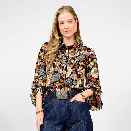 Woman wearing a floral blouse and jeans on a white background