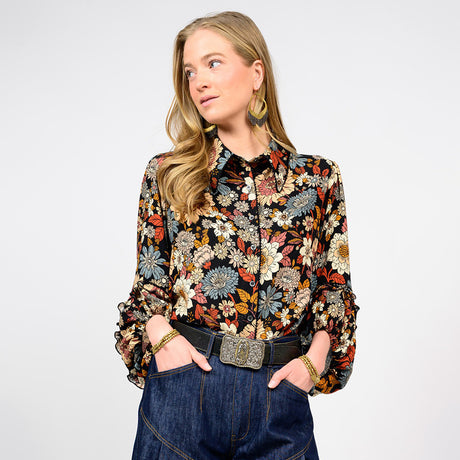 Woman wearing a floral blouse and jeans on a white background