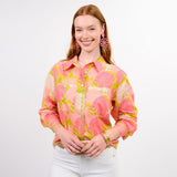 Woman wearing a pink floral blouse with a plain background