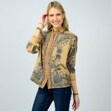 Woman wearing a patterned top on a plain background
