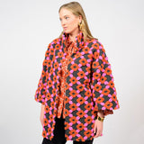 Woman wearing a colorful patterned coat on a white background