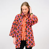 Woman wearing a colorful floral patterned coat on a white background