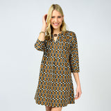 Woman wearing a patterned dress on a plain background