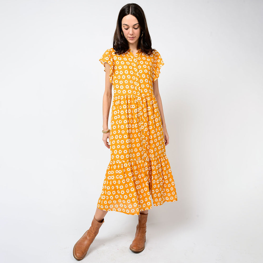 Woman wearing a yellow floral dress on a white background