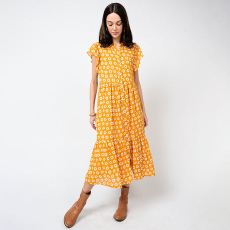 Woman wearing a yellow floral dress on a white background