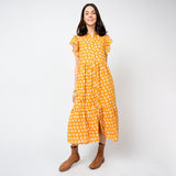 Woman wearing a yellow floral dress on a white background