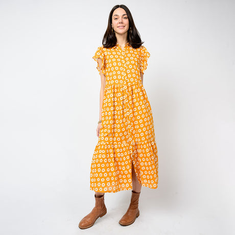 Woman wearing a yellow floral dress on a white background