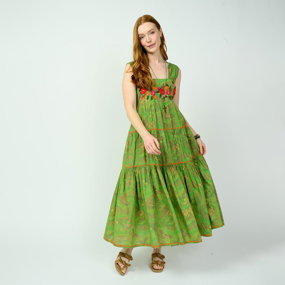 Woman wearing a green dress with floral patterns on a white background