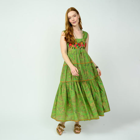 Woman wearing a green dress with floral patterns on a white background