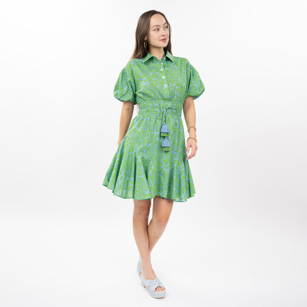 Woman wearing a green patterned dress on a white background