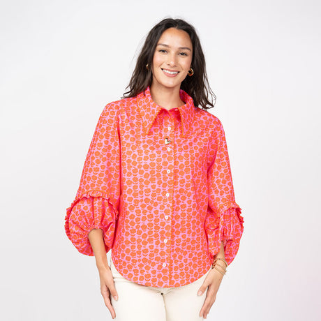 Woman wearing a red patterned blouse on a white background